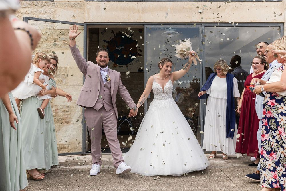 Sortie de mairie festive pour les jeunes mariés sous une pluie de pétales, photo de mariage dynamique à Chauray ou Niort (79).