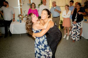 Two guests share a joyful dance moment at a wedding celebration.