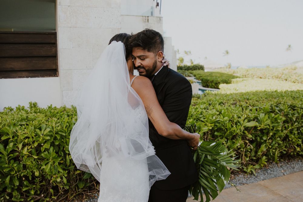 Tender embrace between newlyweds on their wedding day at tropical venue.
