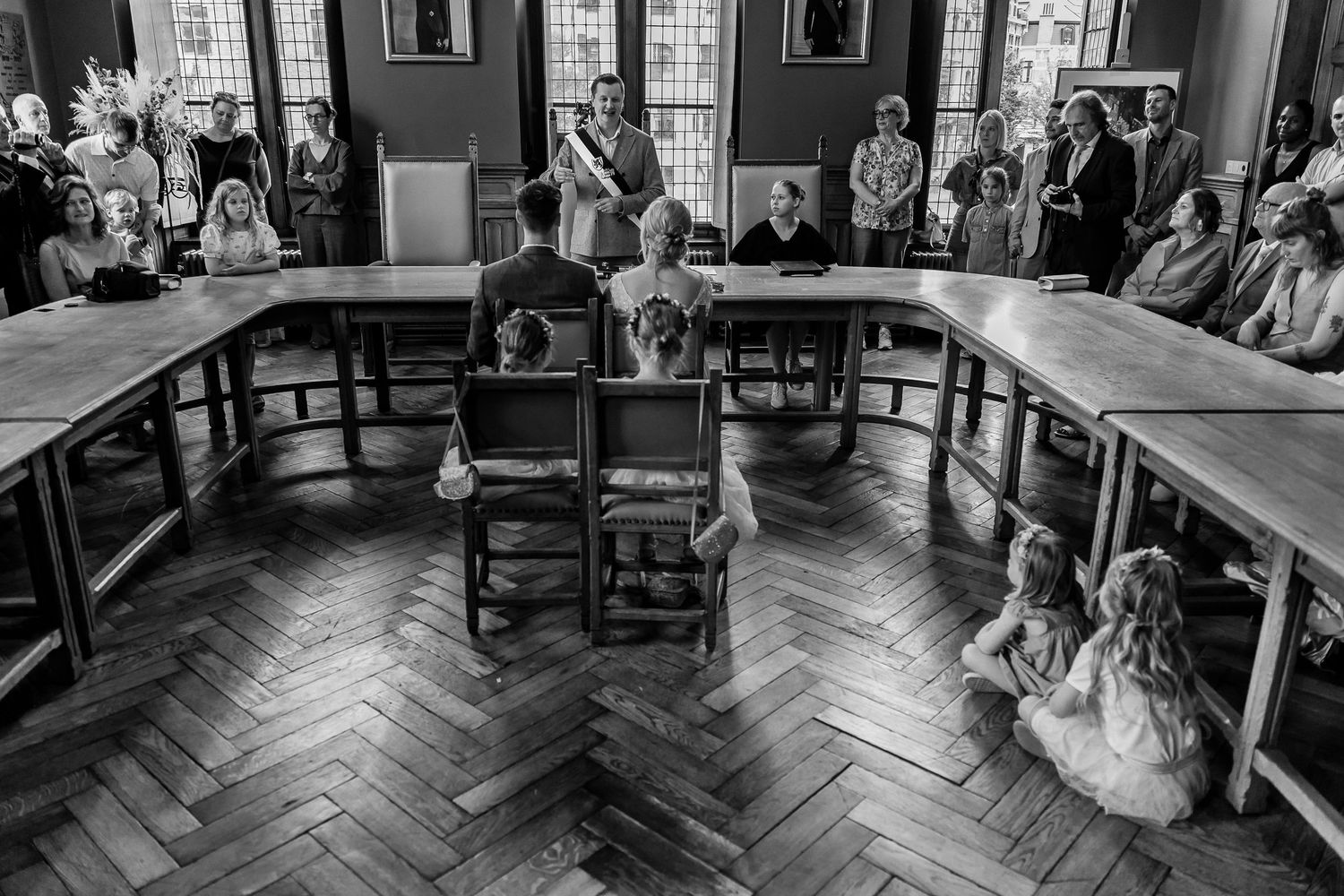 Panoramic view of wedding ceremony venue with herringbone wood floors and antique furnishings.