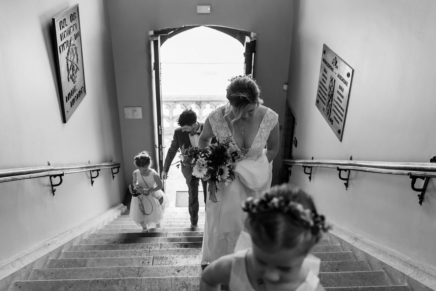 Wedding party walking down iconic stone staircase in elegant venue.