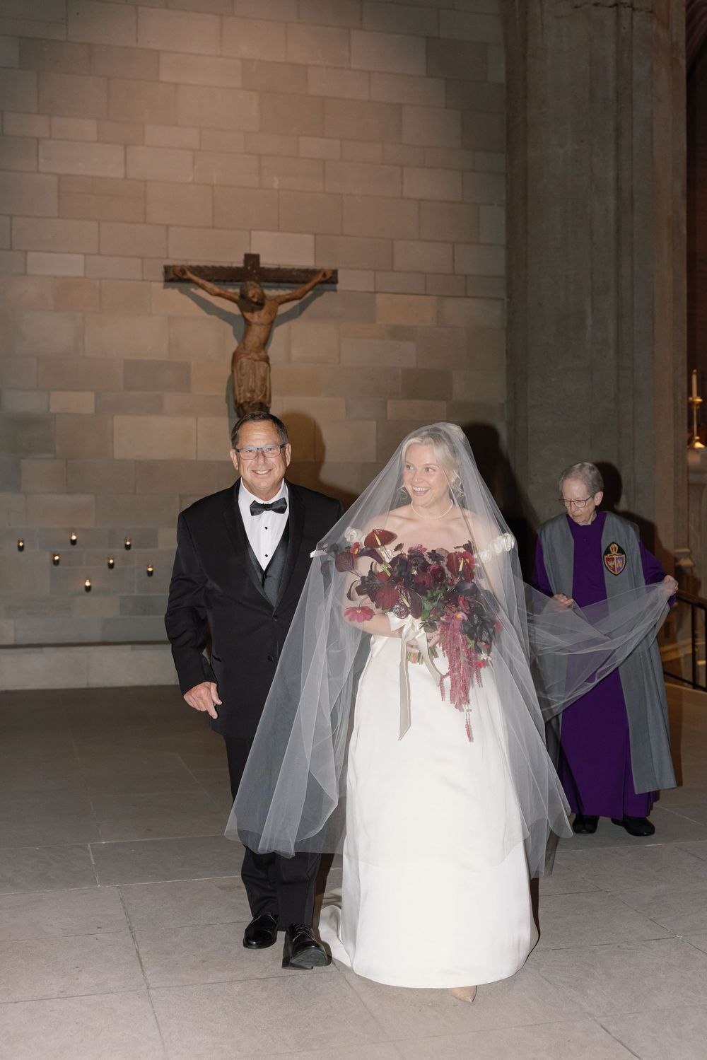 Four sequential photos showing a bride and groom walking through a church interior with stone walls and a crucifix.