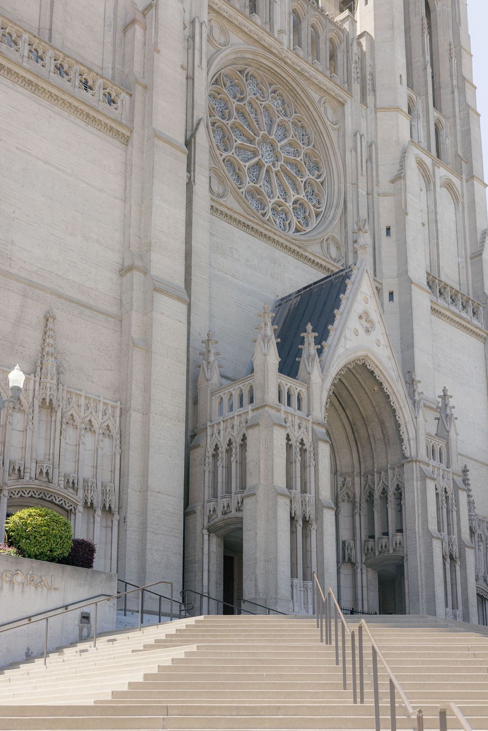 Exterior view of a grand Gothic cathedral with ornate stone steps and arched doorways.