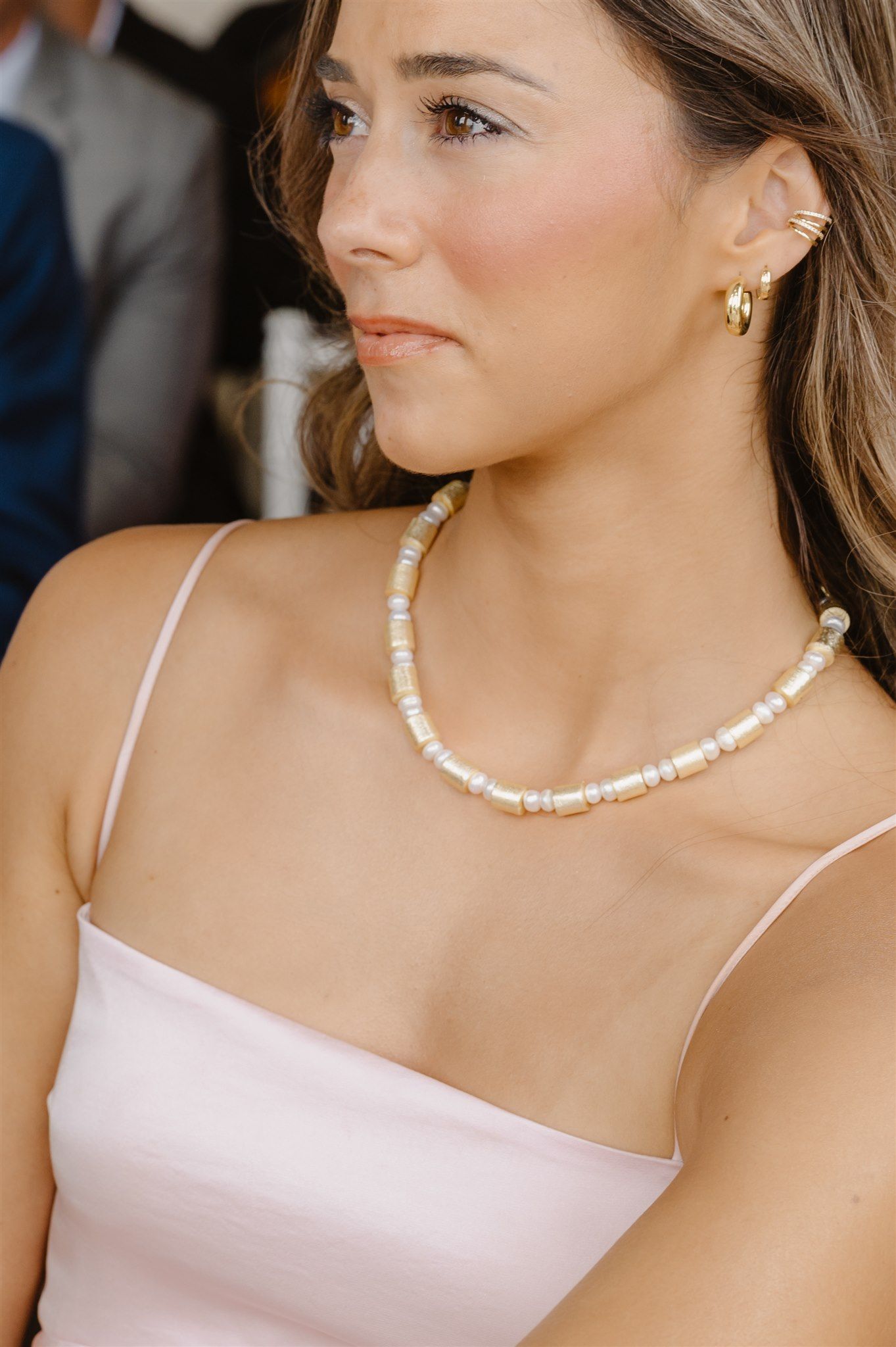Close-up of an elegant pearl necklace worn with a white dress.