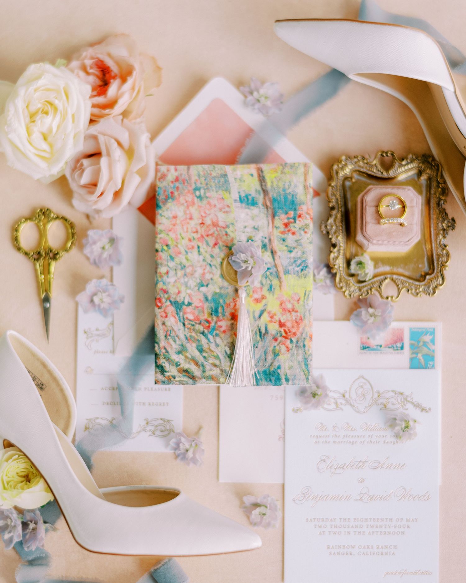 Elegant wedding flatlay with white shoes, roses, florals and invitation suite.