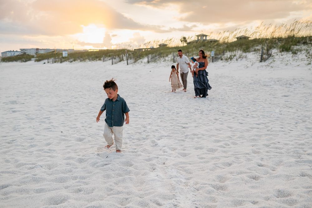 A couple playing and running together on a pristine beach at golden hour.