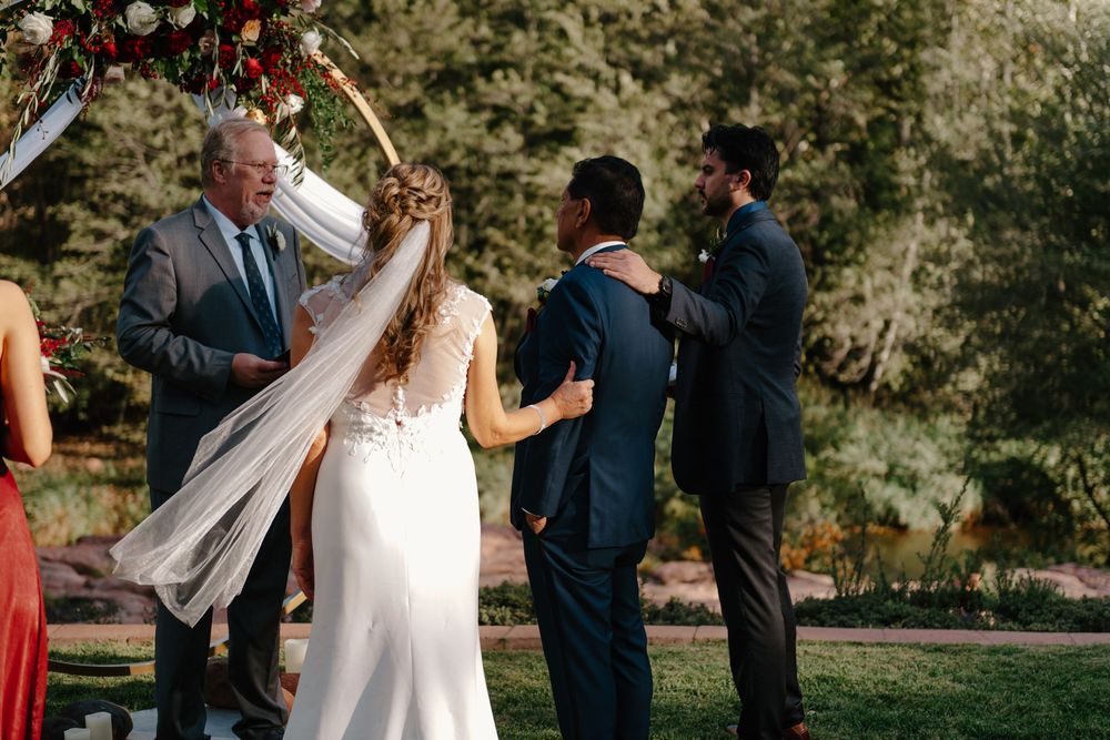 Bride and groom share a romantic dance surrounded by guests at an outdoor wedding reception.
