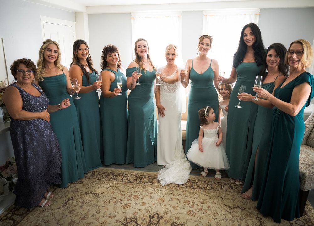 Wedding party group photo with bridesmaids wearing matching teal dresses.