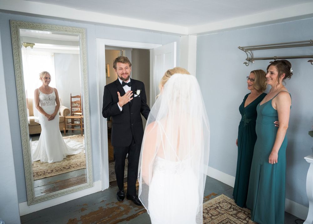 A wedding party gathers in a blue room as they prepare for the ceremony.