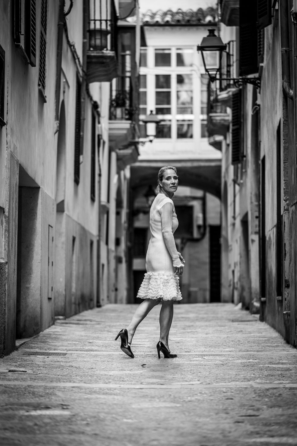 Schwarz-Weiß-Foto einer Frau in Palmas Altstadt, gehend und über die Schulter zurückblickend
