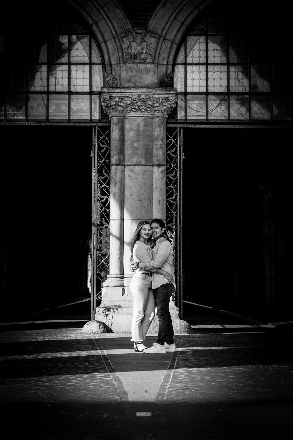 Verliebtes Paar am Eingang des Rijksmuseum in Amsterdam. Schwarz-Weiß-Foto mit Licht auf den beiden