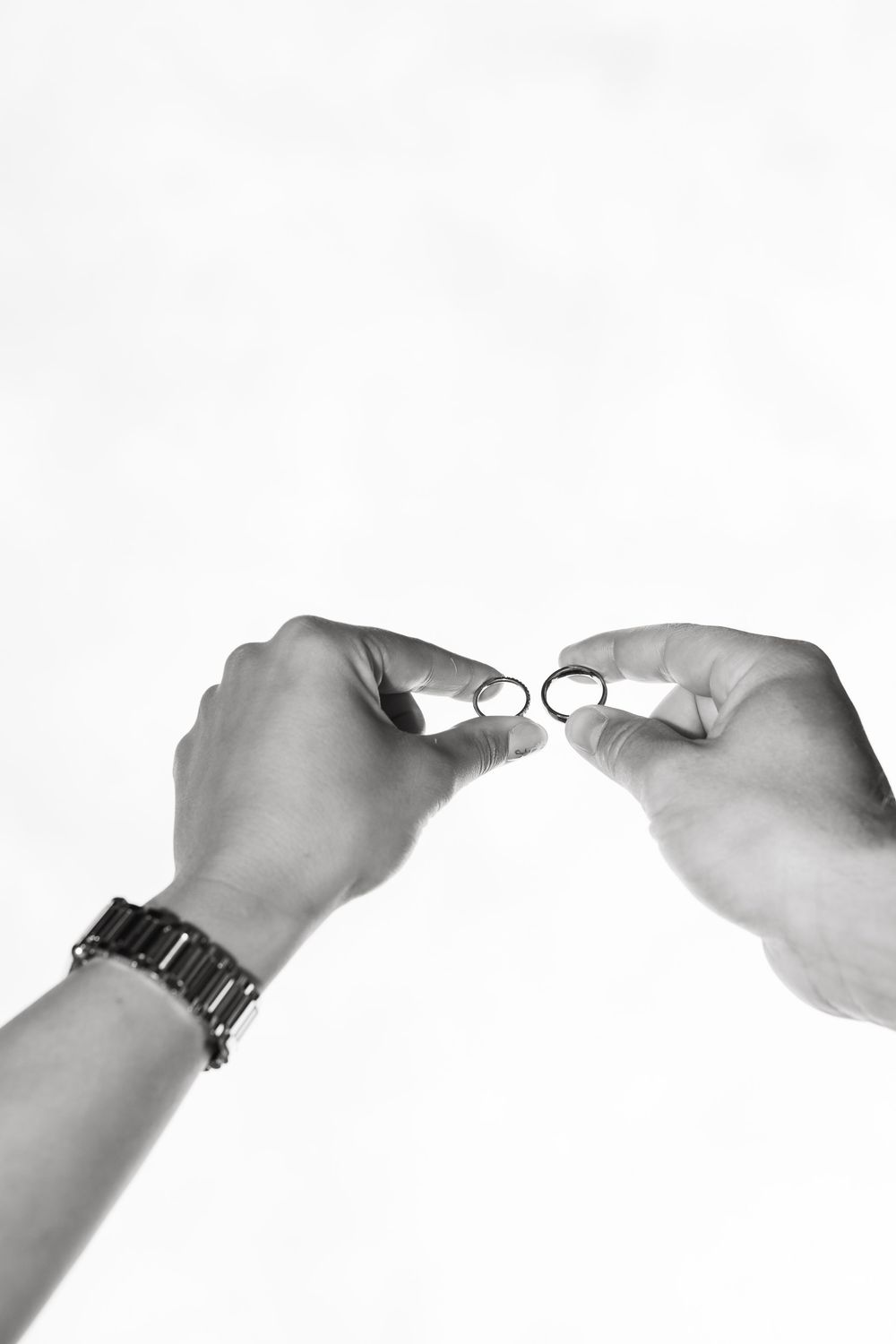 Black and white image sequence showing hands opening a pair of eyeglasses step by step.