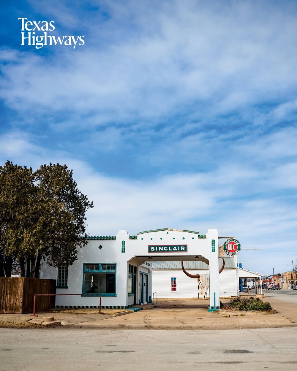 A striking panoramic view of abandoned white buildings along Texas highways under a dramatic cloudy blue sky.