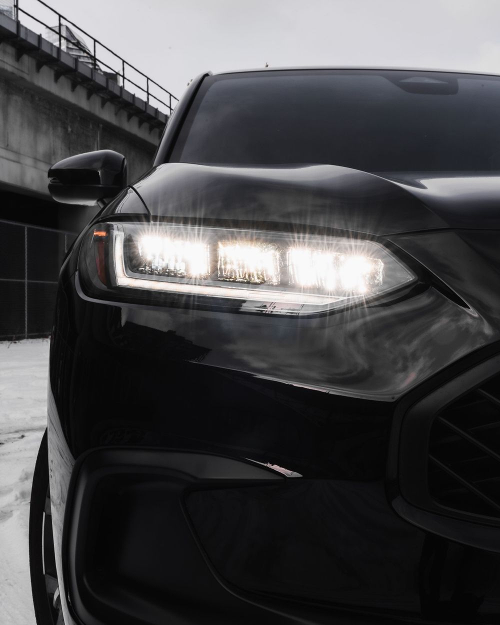 Close-up shot of modern LED headlight on a black luxury car with dramatic lighting. Mtlshutter photography