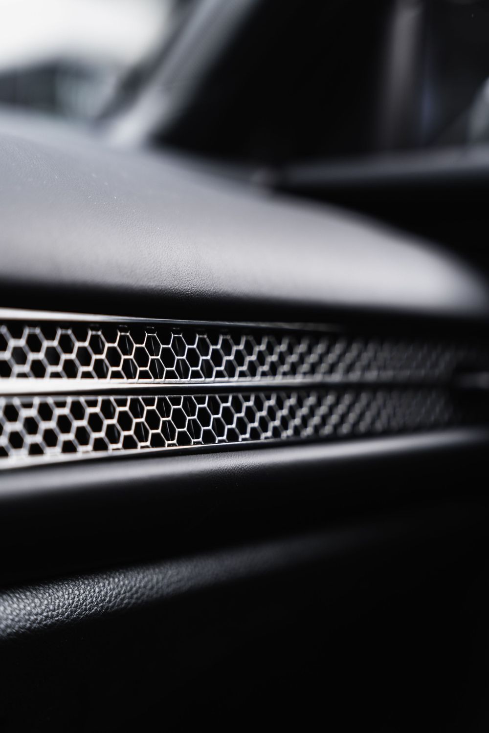 Macro shot of honeycomb pattern speaker grille in a luxury car interior. Mtlshutter photography