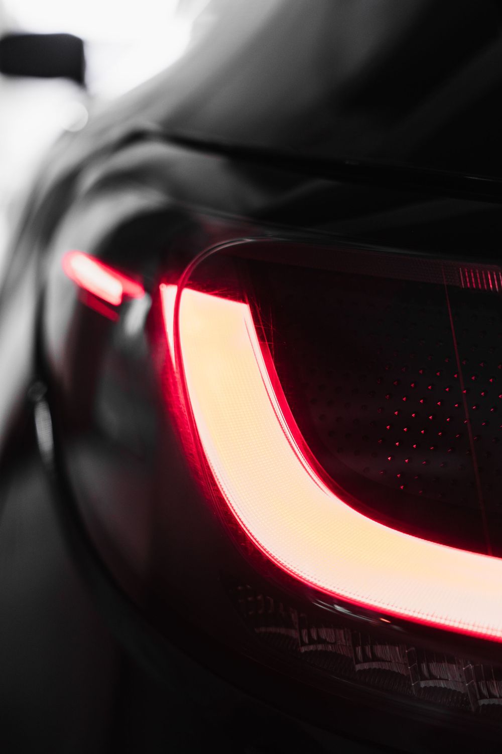 Close-up of a modern car's LED taillight with sleek red illuminated design.Mtlshutter photography