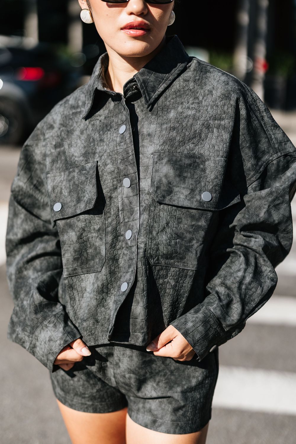 Close-up of gray acid wash denim co-ord set jacket with snap buttons and chest pockets.