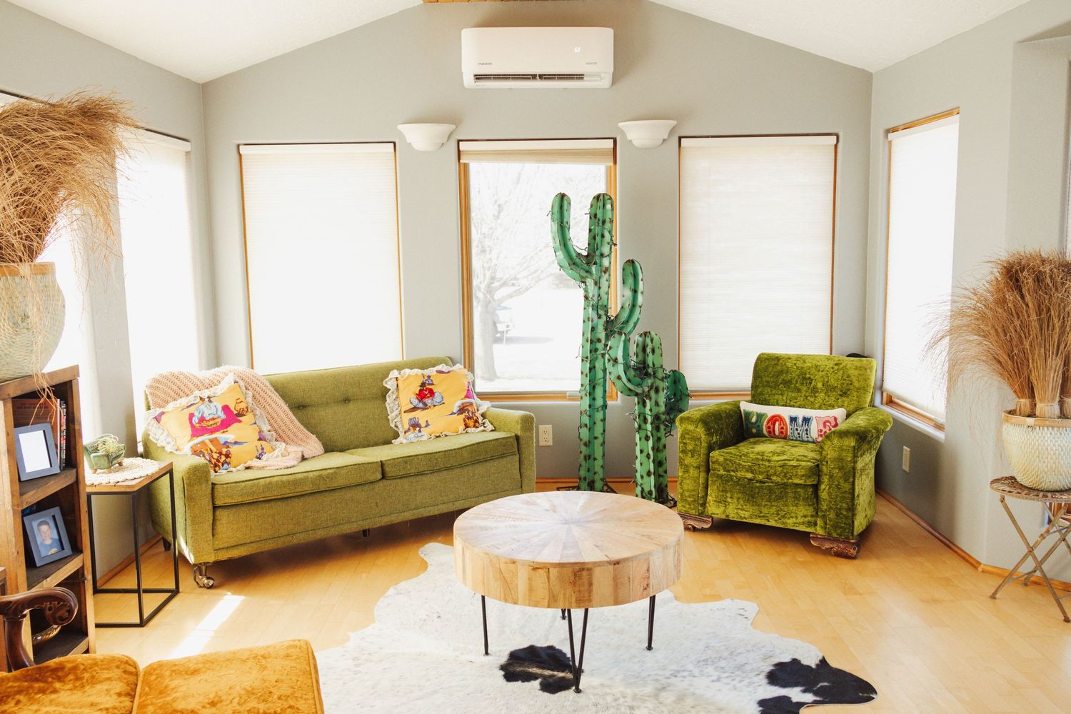 Modern living room interior with green velvet couch and desert-inspired decor.