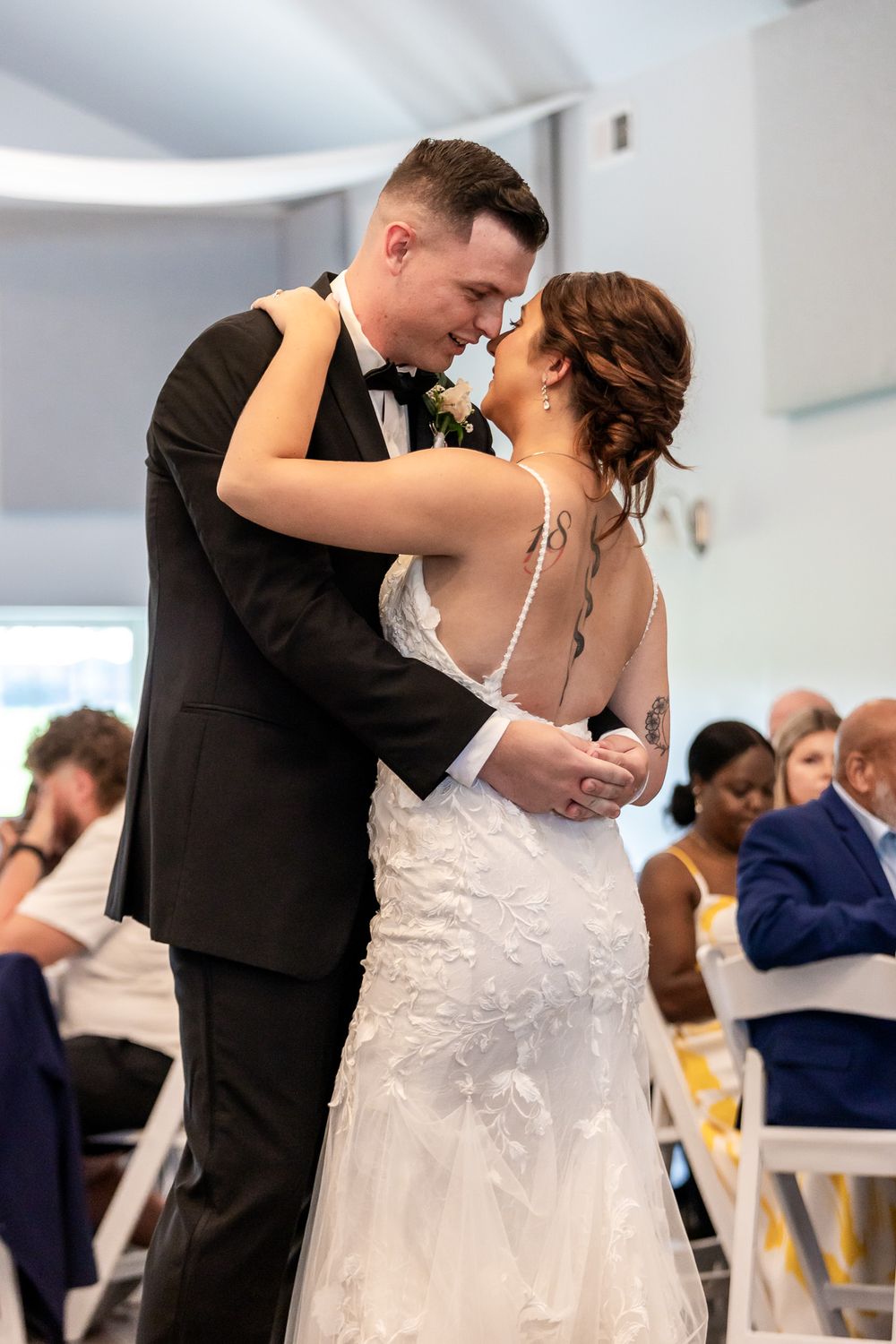 Wedding couple sharing their first dance in an elegant white venue.