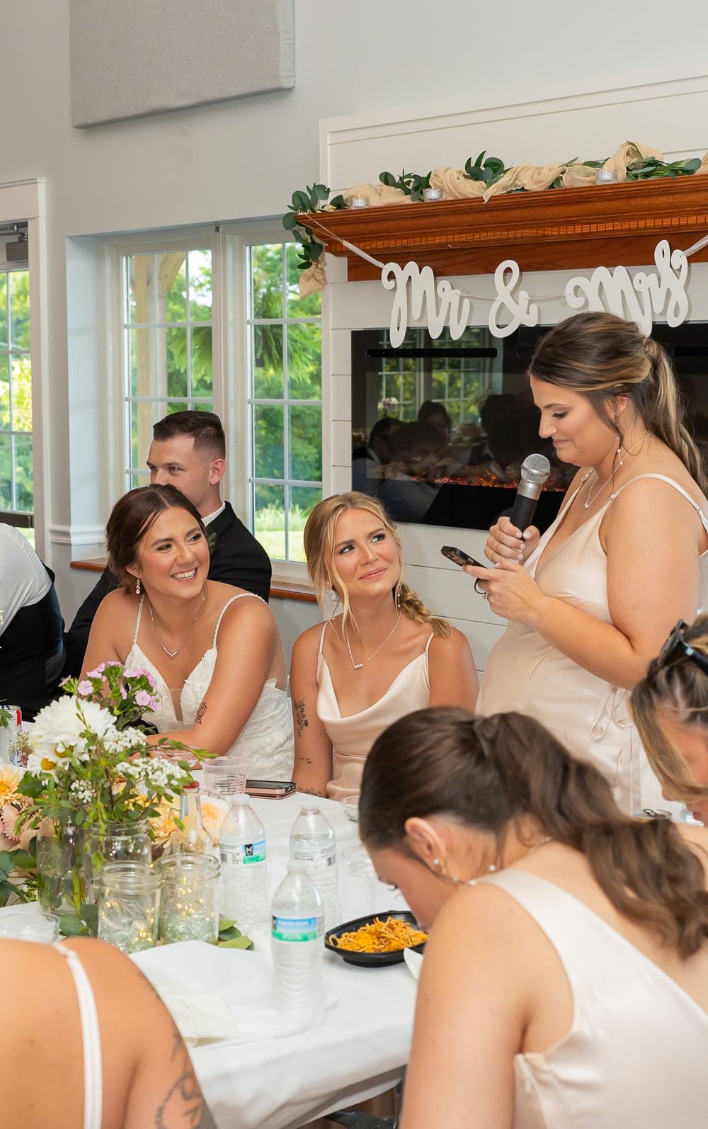 Candid moments captured during wedding reception with guests in light-colored attire.