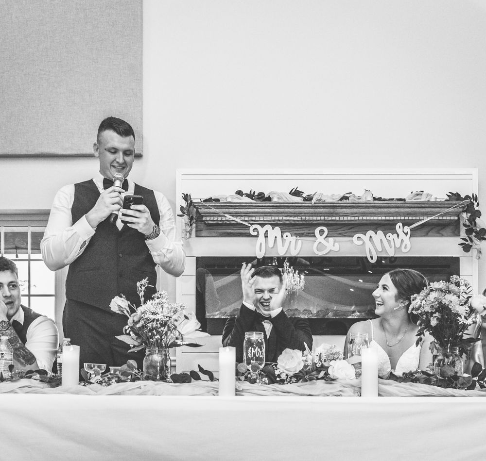 Wedding reception venue decorated with floral arrangements and table settings.