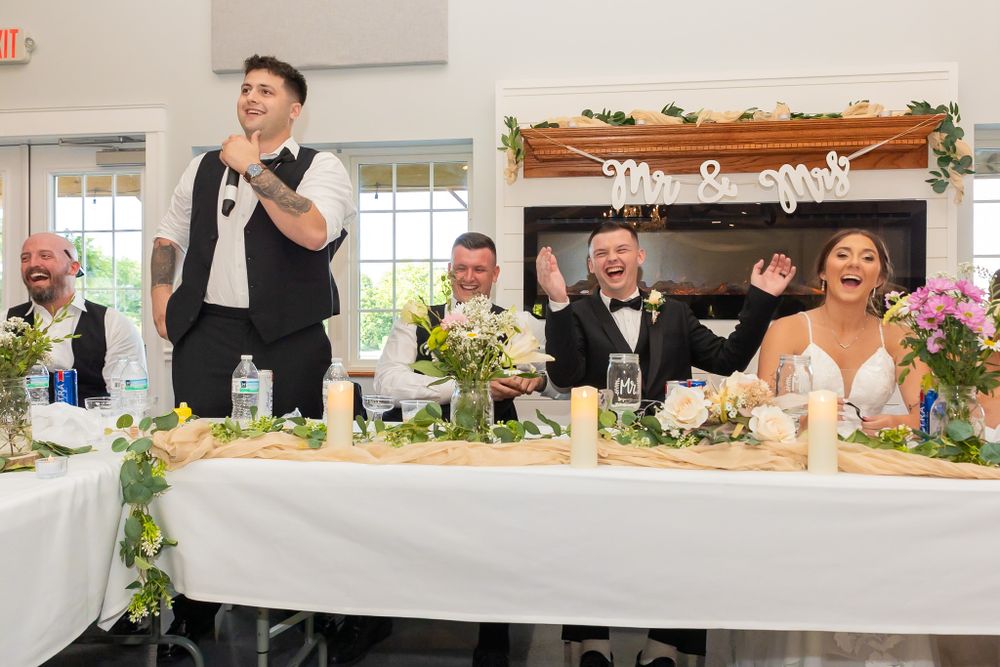 Elegant wedding reception hall with floral centerpieces and white tablecloths.