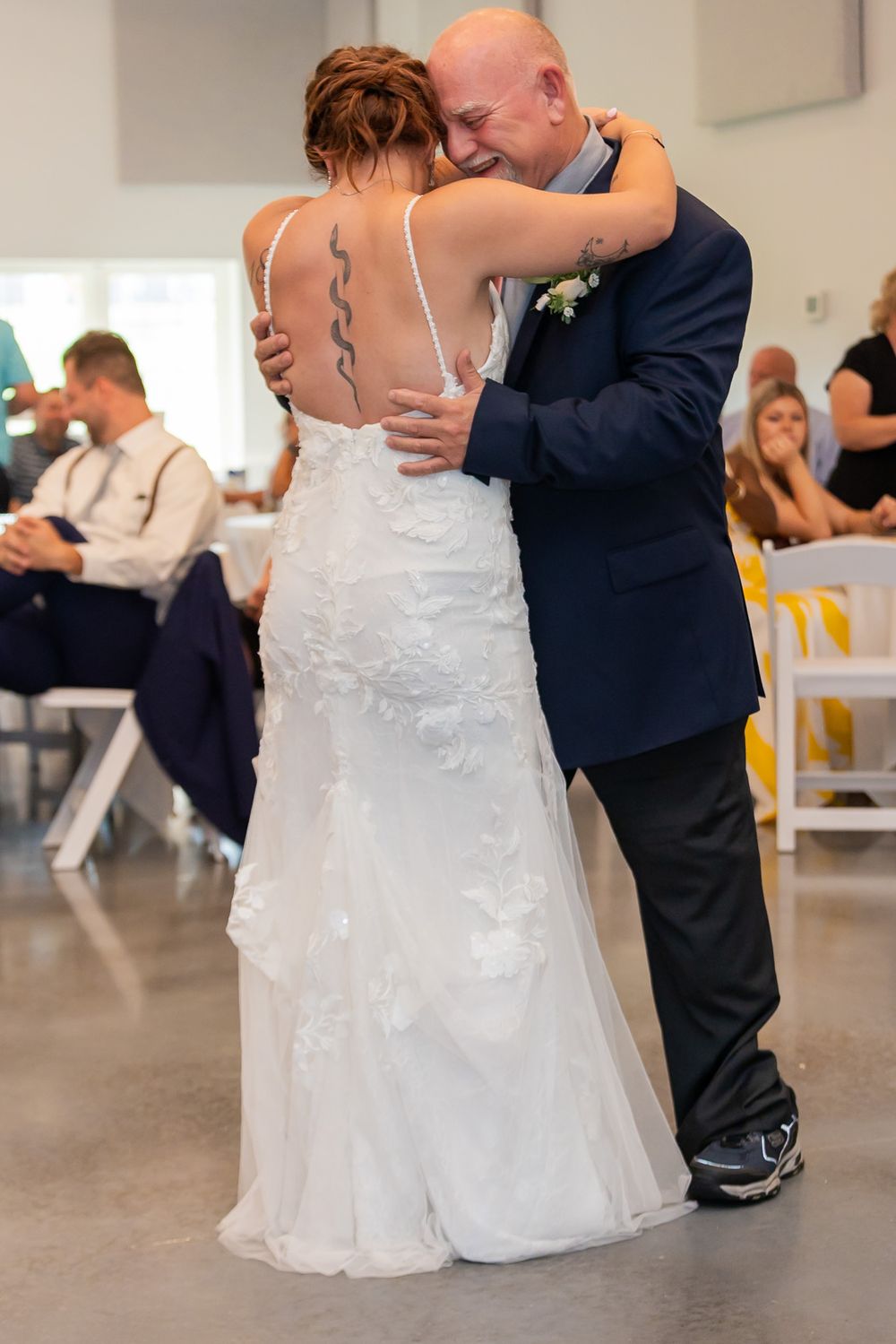 Couple dancing in an elegant white and navy wedding celebration.