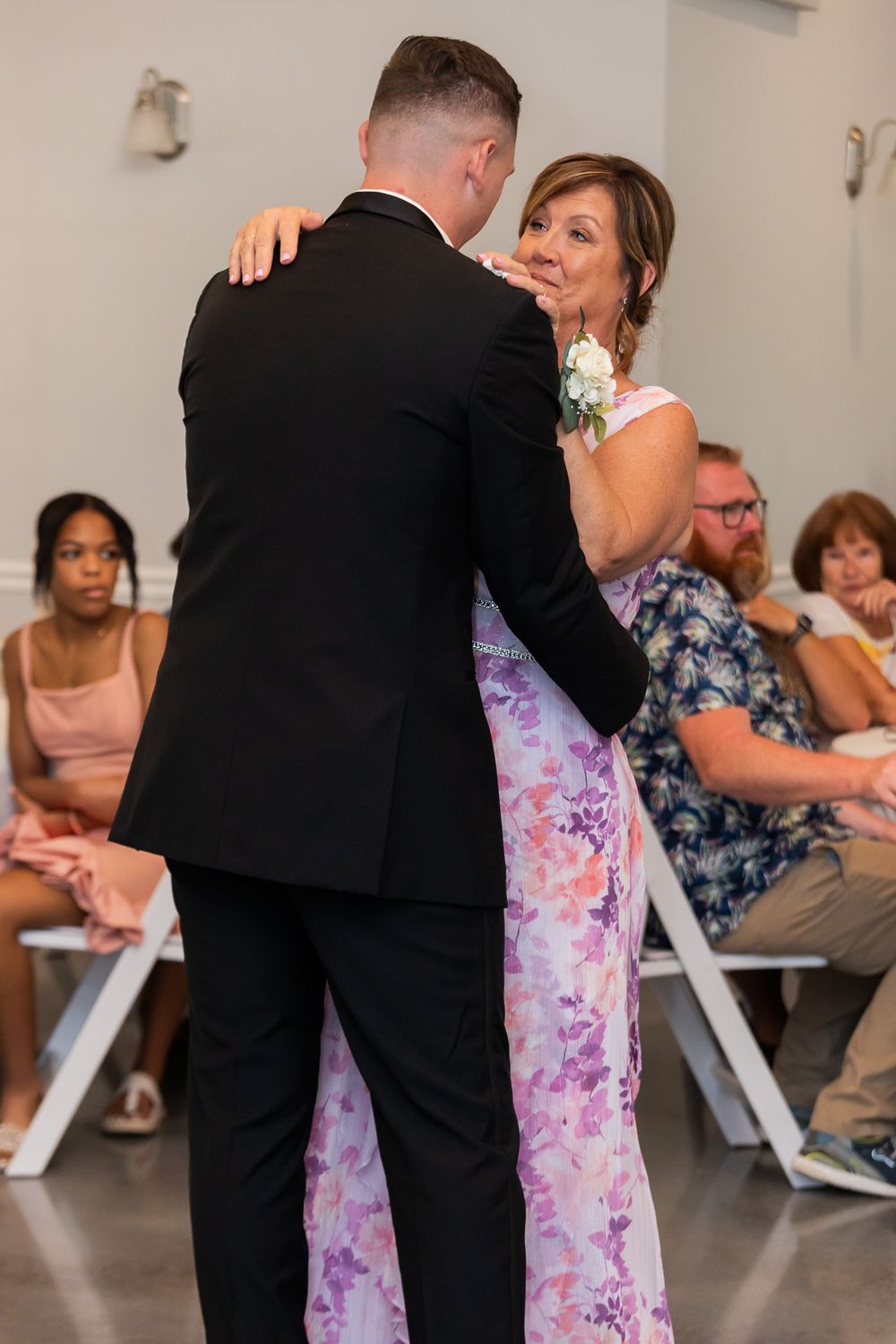 Wedding guests enjoying a celebratory dance at an indoor reception.