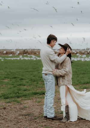 A romantic couple shares tender moments in a series of four photos taken in a grassy field with seagulls flying overhead.