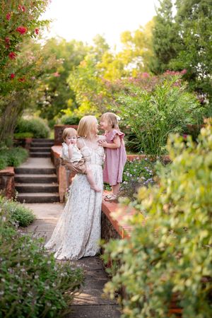 A peaceful garden scene with stone steps and blooming flowers on a warm summer evening.