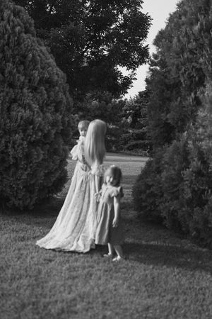 A sequence of black and white photos showing two figures walking together on a grassy hillside path.