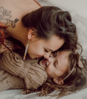 A series of five intimate photos showing a tender embrace and connection between two people lying down.