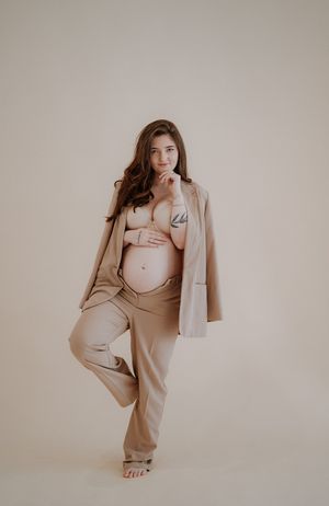 Fashion model poses in beige monochromatic outfit against neutral background in artistic photo series.