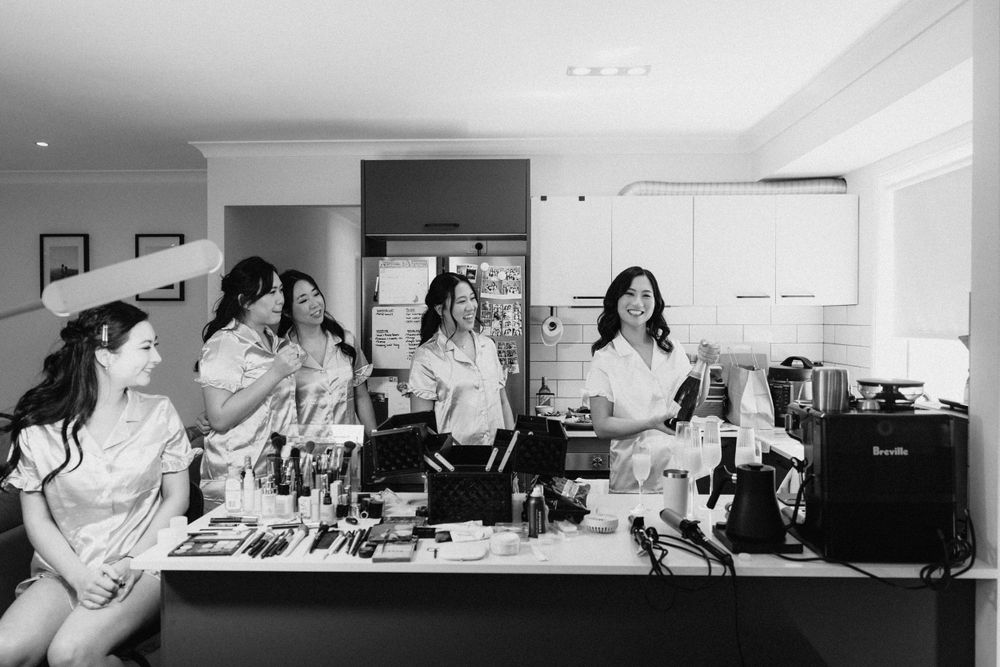Bridal party enjoying lighthearted moments while getting ready at The Refinery, captured in a candid photography style.”