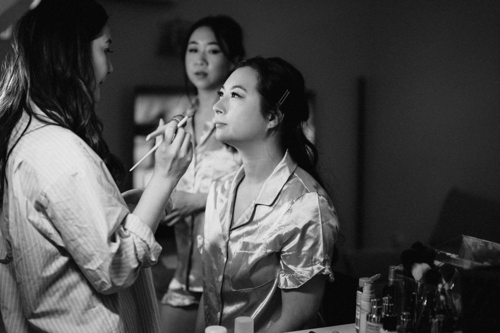“Bride’s intimate moments getting ready at The Refinery, surrounded by vibrant colors, photographed candidly.”