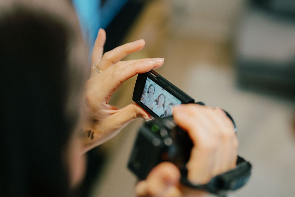 Guest taking photo on smartphone at wedding reception.
