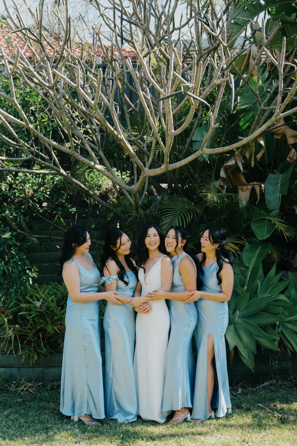 “Bridal party laughing and celebrating while getting ready at The Refinery, captured in a candid photography approach.”