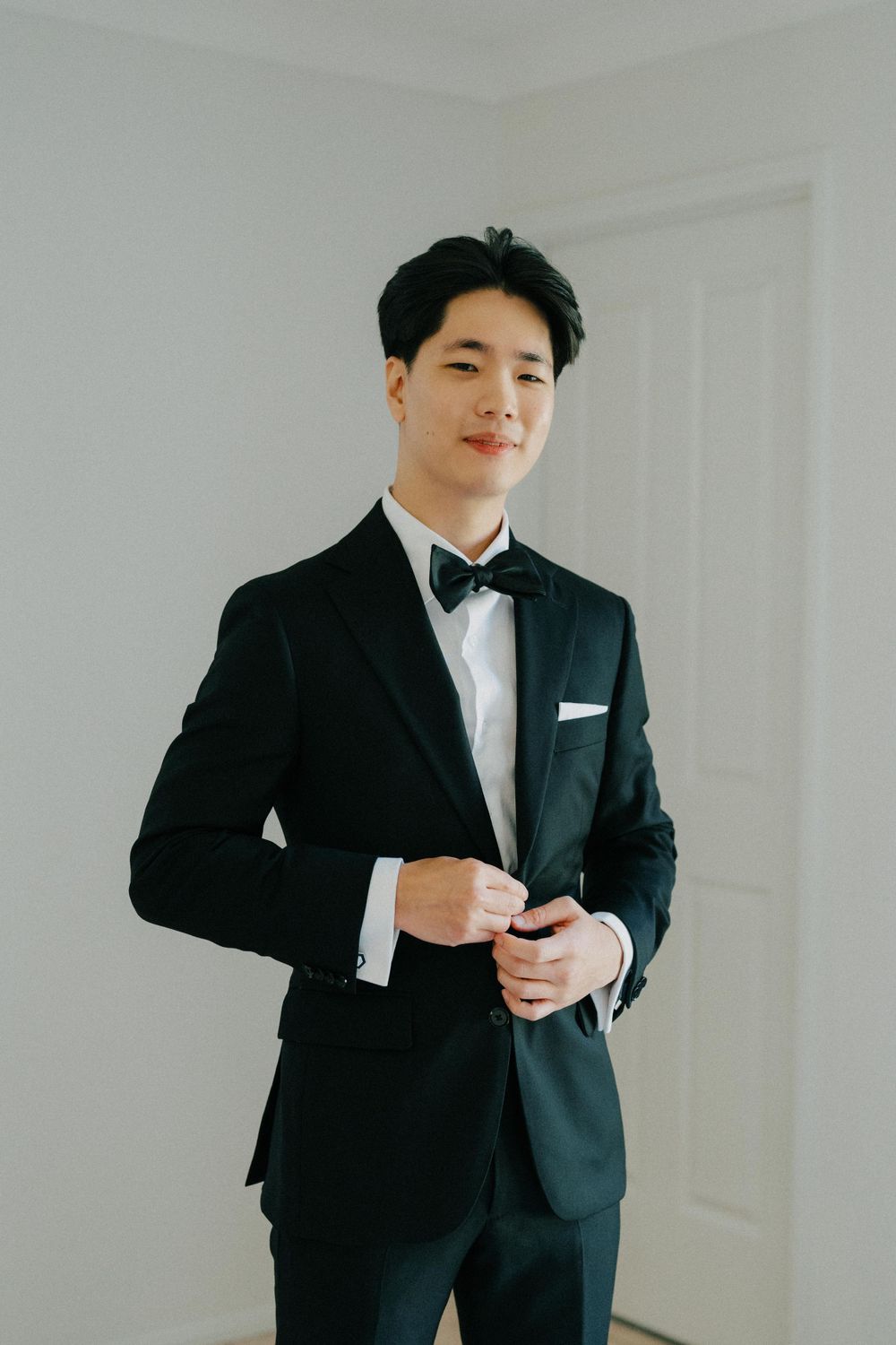 “Groom adjusting tie before the ceremony at The Refinery, photographed in a documentary wedding photography style.