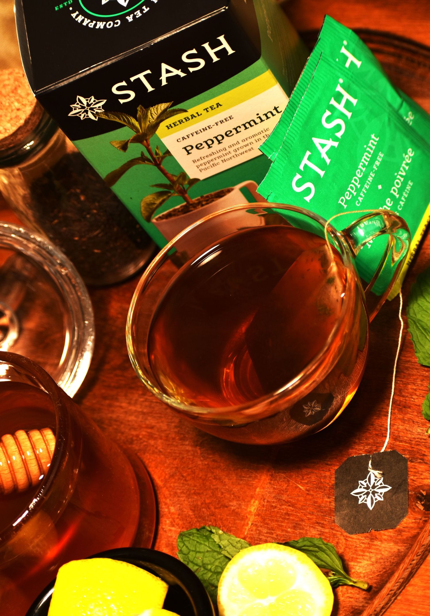 Multiple cups of Stash peppermint tea with tea bags steeping on a wooden surface.