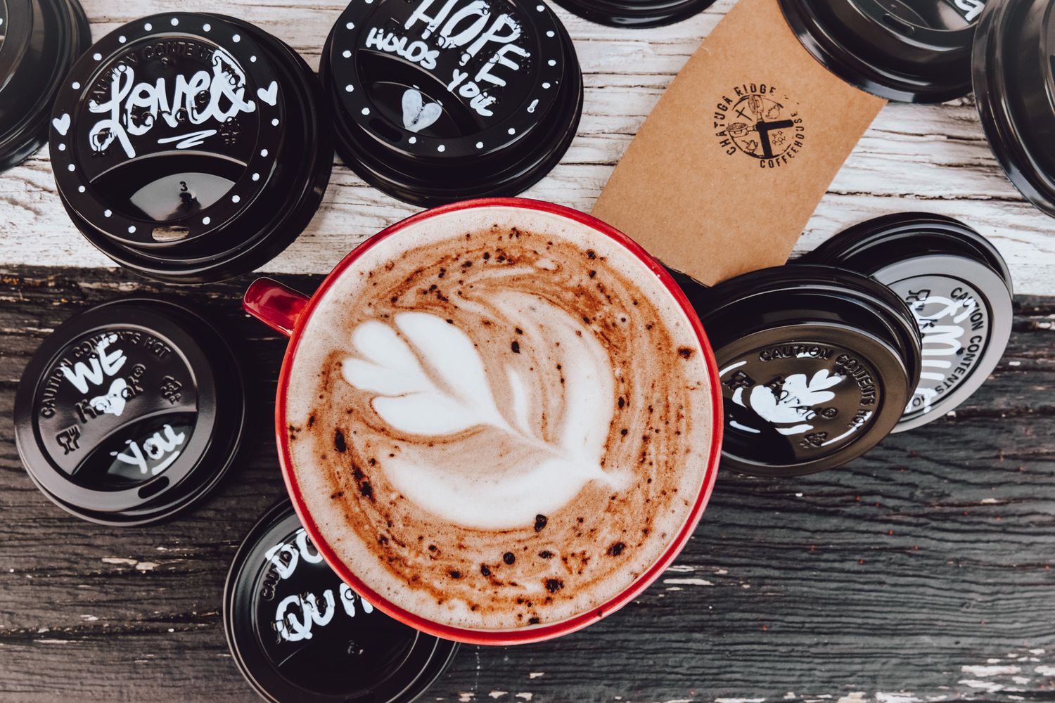 Artistically arranged coffee cups with latte art designs on a wooden surface.