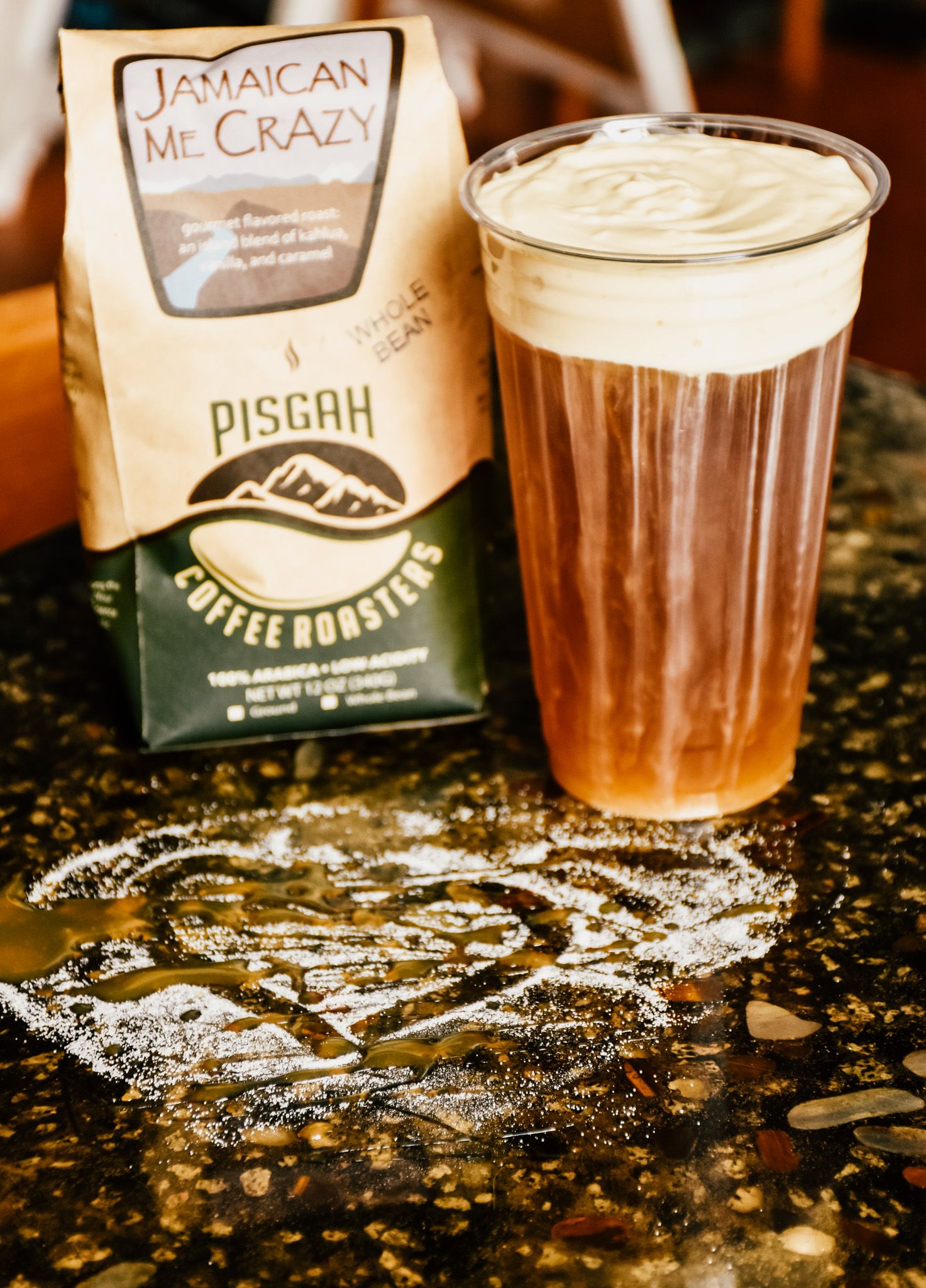 Coffee beverages with whipped cream and spices on a sparkly counter surface.