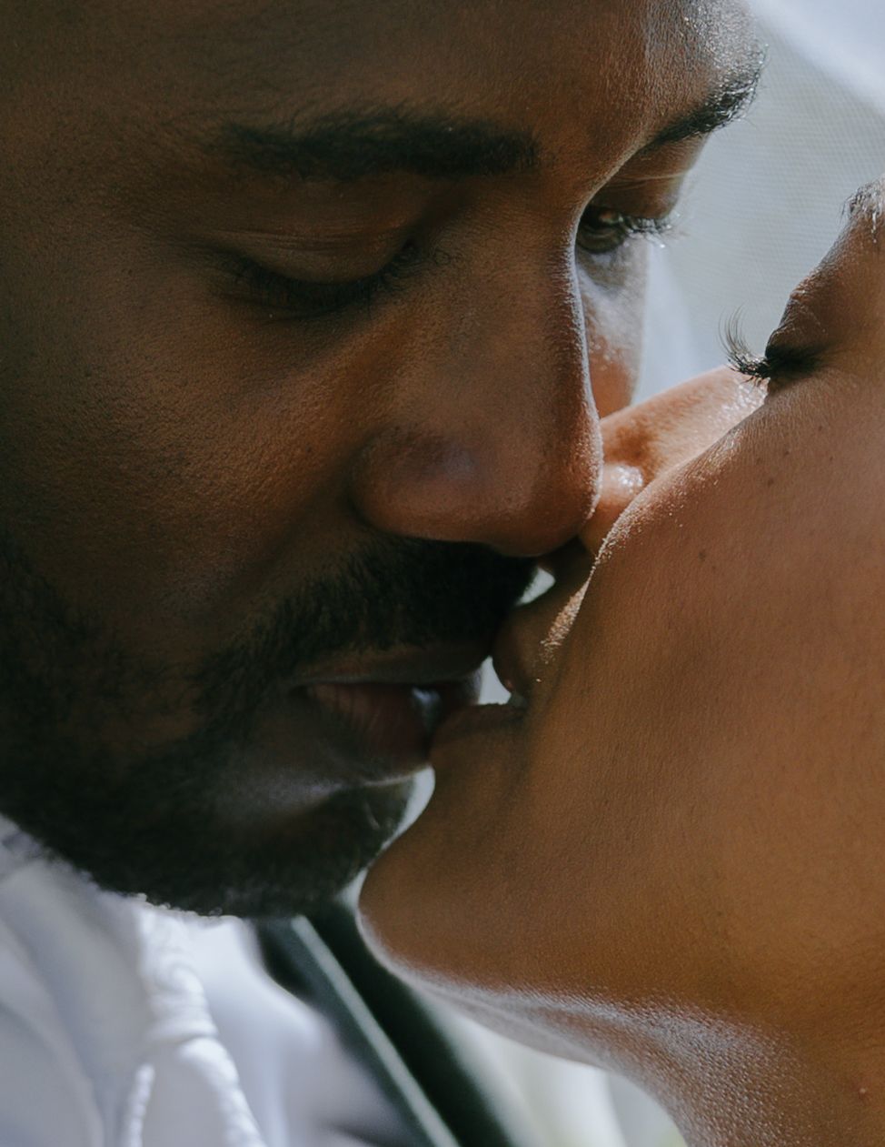 Close up of two people sharing a tender intimate kiss with soft lighting making for a romantic moment.