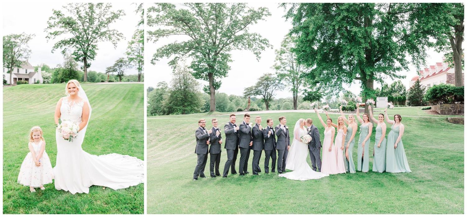 Wedding party in formal attire poses on lush green lawn with beautiful summer garden backdrop.