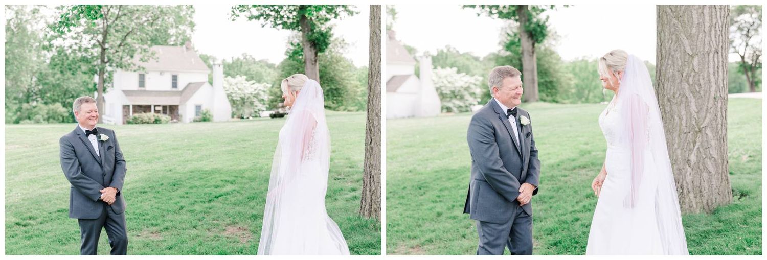 An outdoor wedding first look moment between two people in traditional formal attire on a grassy lawn with trees.