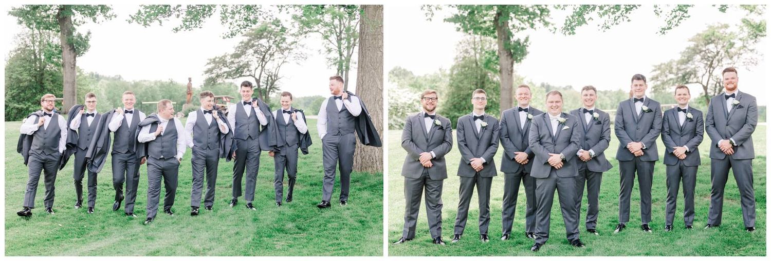 Wedding party members in matching gray suits pose together on a grassy lawn for formal group photos.