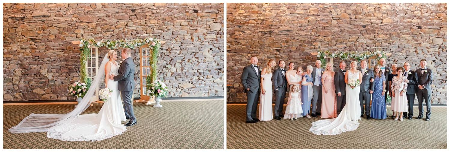 A wedding couple and their bridal party in blue dresses pose against a rustic brick wall for formal portraits.