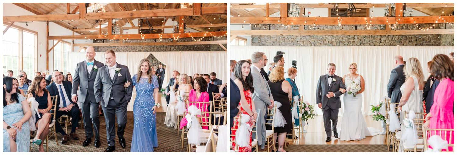 Guests in formal attire attend a wedding reception in a rustic wooden barn venue with natural lighting streaming in.