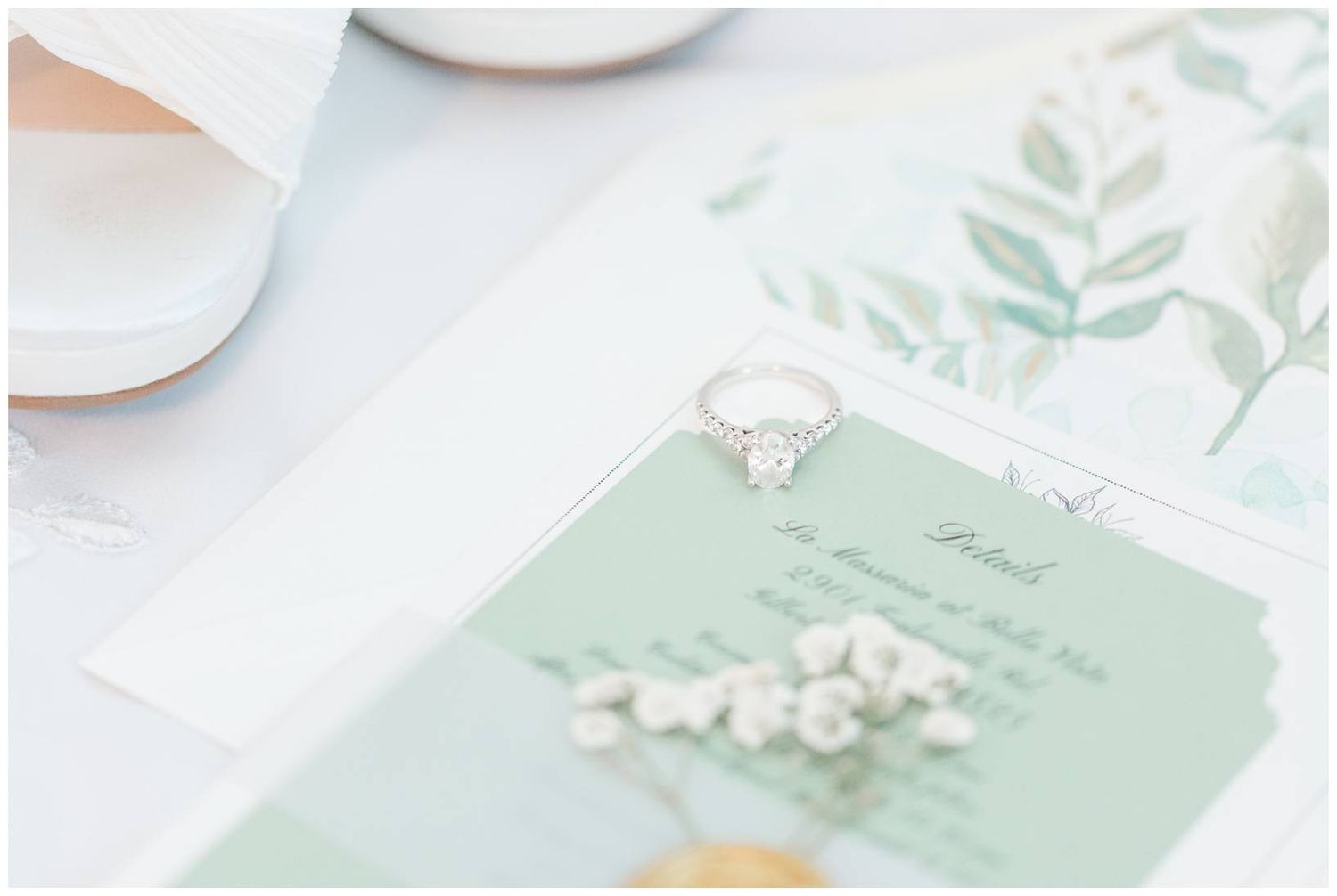 Soft mint green wedding invitation with delicate white floral details and watercolor botanical designs on a light background.