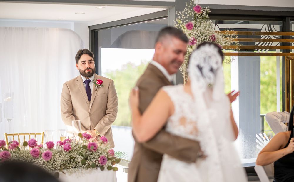 A couple shares a special moment at their outdoor wedding ceremony with floral decorations and natural lighting.