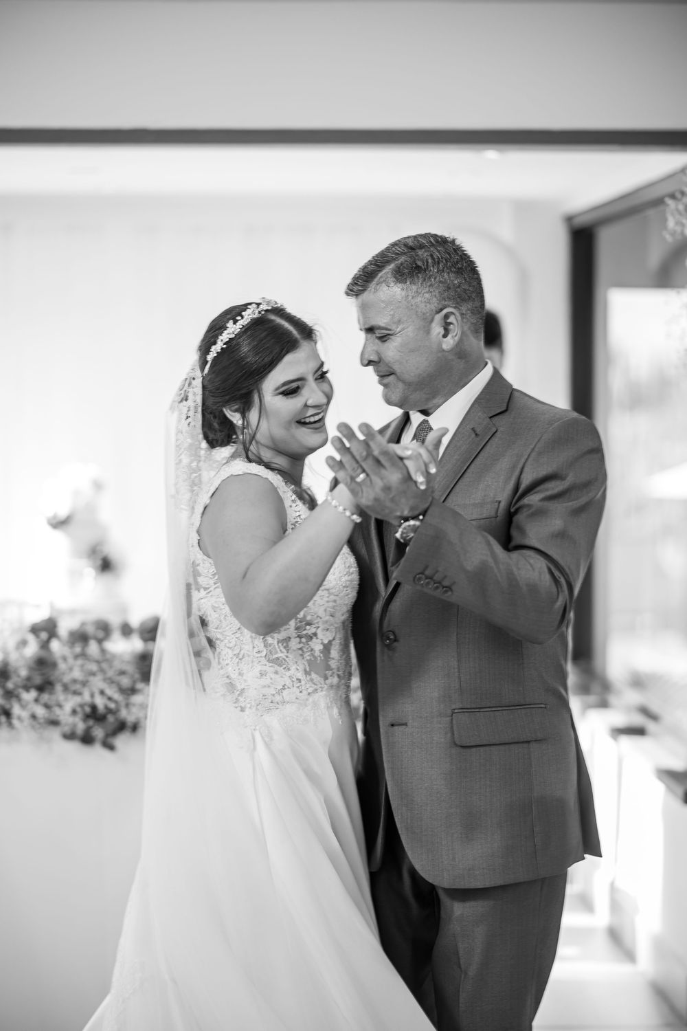 A bride and groom share an intimate moment together during their wedding celebration in black and white photography.
